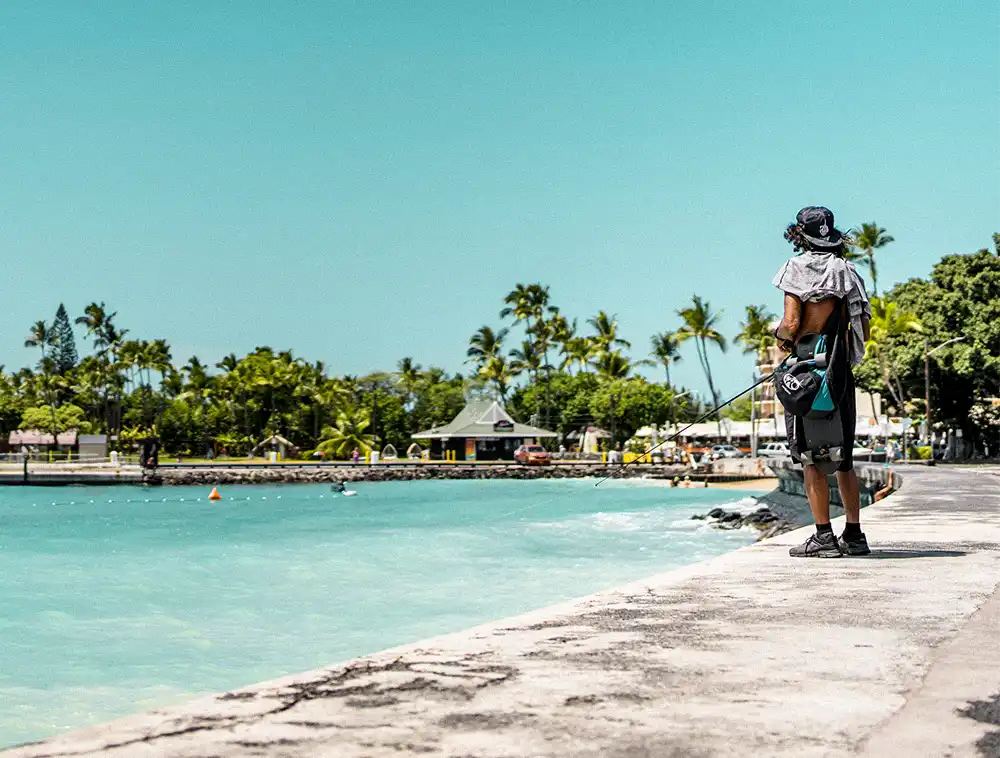 Mann angelt an einem Strand auf Hawaii, den Du mit Hannes Hawaii Tours bereisen kannst.