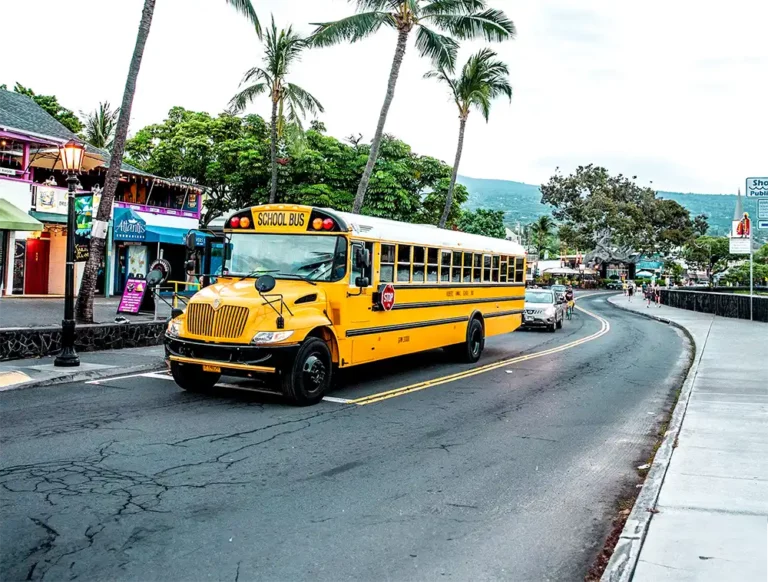 Ein gelber, amerikanischer Schulbus shuttlet die Gäste von Hannes Hawaii Tours beim Ironman Hawaii.