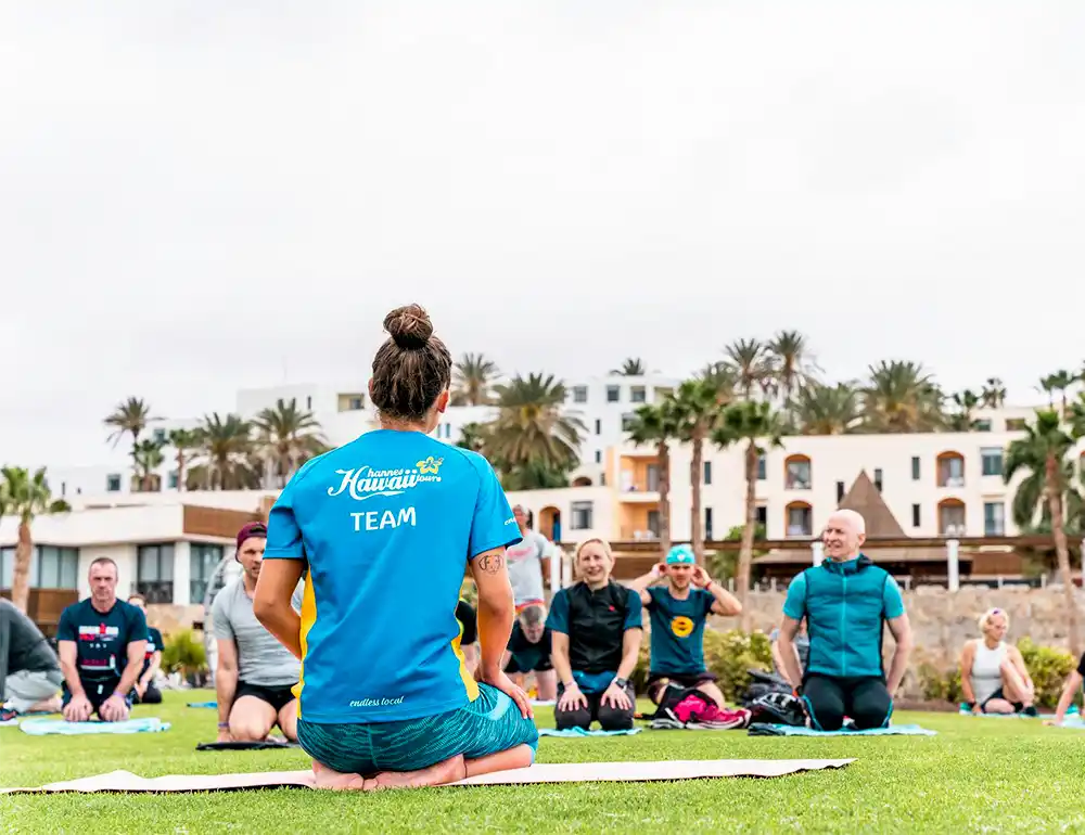 Hannes Hawaii Tours-Guide bei einem Workshop mit den Athlet:innen im Gras.